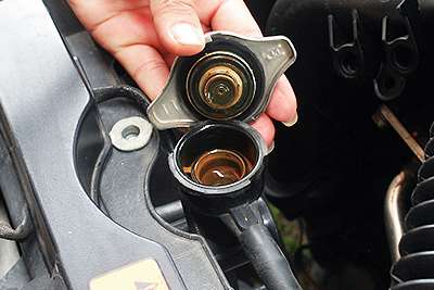 Townsville mechanic showing rusty radiator cap fluid corrosion