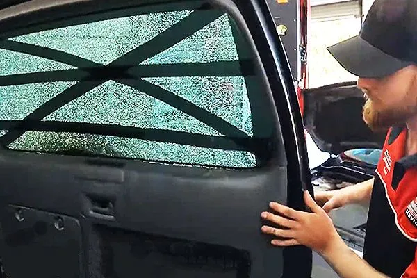 Mechanic repairs broken car windscreen while servicing a car in Townsville area